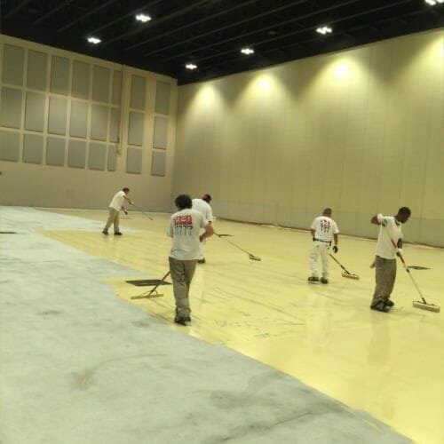 group of people epoxy coating a floor