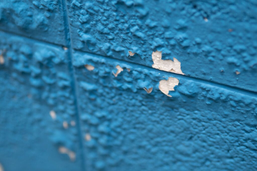 peeling and bubbling paint on a blue wall 