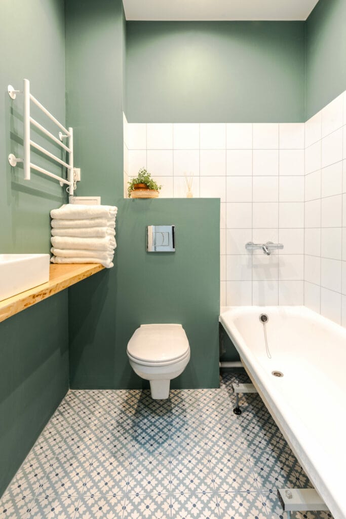 minimalistic elegant design of bathroom in wormwood green color, installation, white bath. wall paint for wet room using