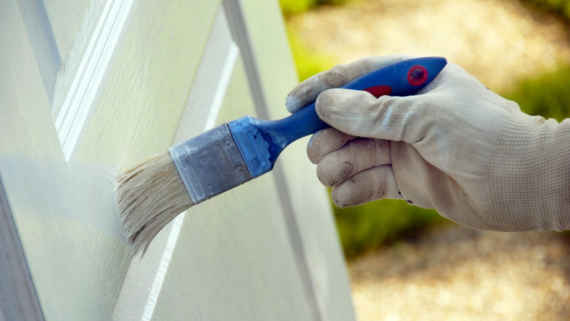 painting wooden door in white color by blue brush